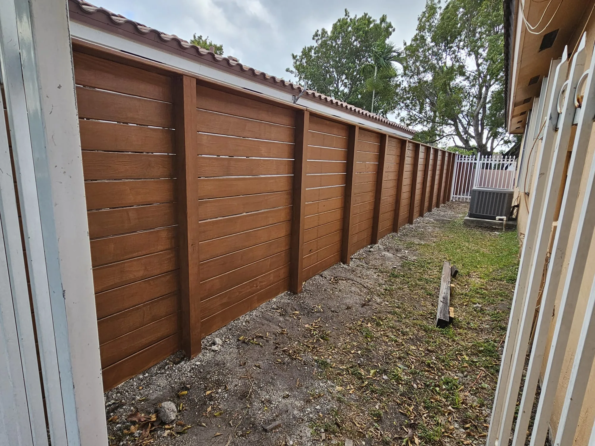 Brown full-privacy fence installed beside a South Florida home
