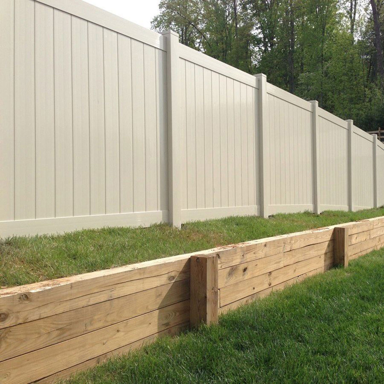 White vinyl privacy fence installed along a landscaped yard