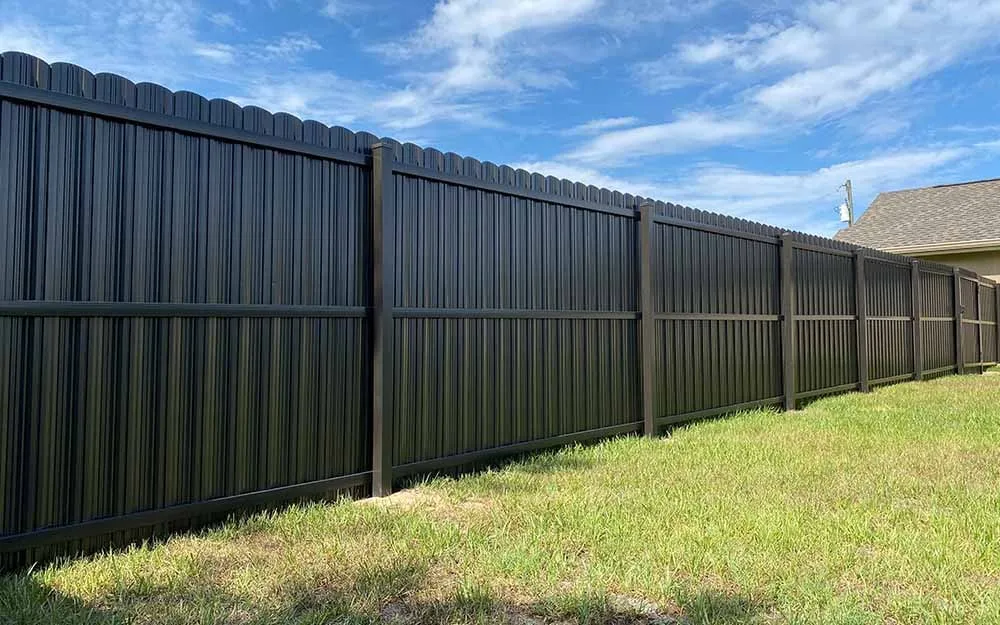 Black Dura Fence full-privacy metal fence installed beside a South Florida home